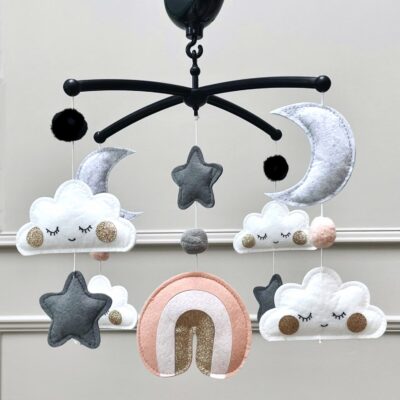 Muziekmobiel met roze regenboog van vilt – zwarte houder met wolkjes, maantjes, sterretjes en druppels van goud – handgemaakt ontwerp van Kiekepiep